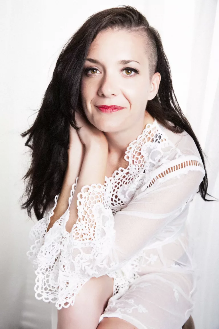 funky bride wearing a white lacy wrap sitting on a chair