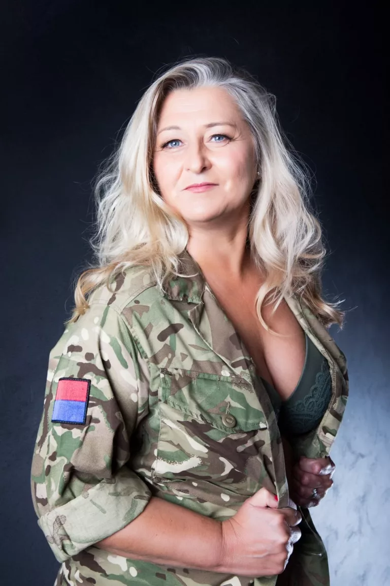 a woman wearing a camouflage jacket and lingerie